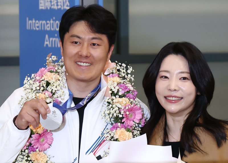 2026 밀라노·코르티나담페초 동계 올림픽에서 한국에 400번째 올림픽 메달을 안겨준 스노보드 김상겸이 10일 오전 인천국제공항을 통해 귀국하며 은메달을 들어보이고 있다. 오른쪽은 아내 박한솔 씨. 2026.2.10 ⓒ 뉴스1 김민지 기자