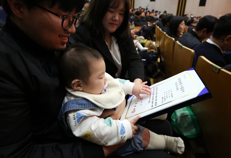 [서울=뉴시스] 이영환 기자 = 한 아이가 5일 오전 서울 중구 부영 태평빌딩에서 열린 부영그룹 시무식에 참석해 출산장려금 지급증서를 바라보고 있다. 2026.02.05. 20hwan@newsis.com
