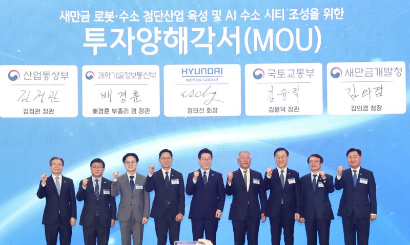 이재명 대통령이 27일 전북 군산 새만금컨벤션센터에서 열린 새만금 로봇·수소·AI 시티 투자협약식에 참석해 기념촬영을 했다.사진은 왼쪽부터 김용범 정책실장, 김성환 기후에너지환경부 장관, 김정관 산업통상부 장관, 배경훈 부총리 겸 과학기술정보통신부 장관, 이재명 대통령, 정의선 현대자동차 회장, 김윤덕 국토교통부 장관, 김의겸 새만금청장, 김관영 전북특별자치도지사. 전북도 제공