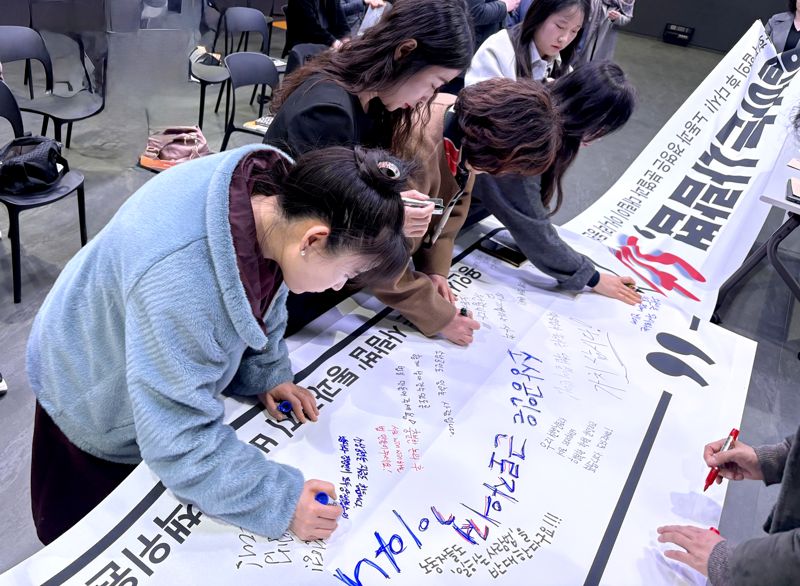 용인시학원연합회 주최 일하는 사람 기본법 논의 중단 촉구 설명회에서 참석자들이 플래카드에 메시지를 적고 있다. 용인시학원연합회 제공