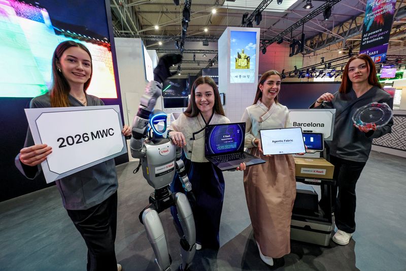 KT 모델들이 MWC 26 피라 그란 비아 전시장에서 포즈를 취하고 있다. KT는 서비스형 로봇 플랫폼 'K RaaS' 등 한층 진보한 피지컬 AI 솔루션들을 선보일 예정이다. KT 제공