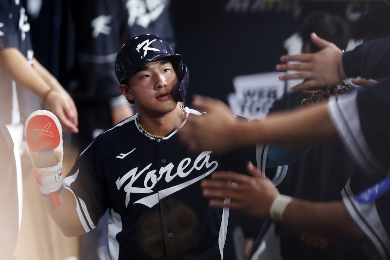 [서울=뉴시스] 조성우 기자 = 한국 3회초 공격 1사 주자 2, 3루서 문보경의 내야 땅볼 때 3루 주자 안현민이 홈인한 뒤 더그아웃에서 동료들과 하이파이브하고 있다. 2025.11.09. xconfind@newsis.com