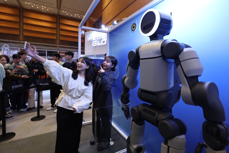 4일 서울 강남구 코엑스에서 열린 ‘2026 스마트공장·자동화산업전(AW 2026)’에서 관람객이 아틀라스 양산형 모델과 셀카를 찍고 있다. ‘CES 2026’에서 처음 공개된 아틀라스가 한국에서 일반인을 대상으로 공개되는 것은 이번이 처음이다. 2026.3.4 ⓒ 뉴스1 박지혜 기자