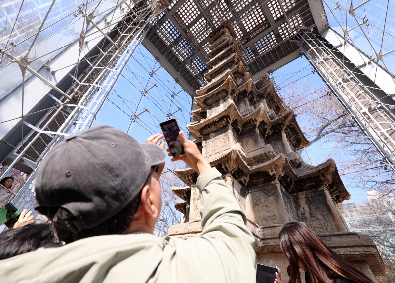 [서울=뉴시스] 이영환 기자 = 4일 오후 서울 종로구 탑골공원에서 시민들이 국보 2호 원각사지 십층석탑을 살펴보고 있다.종로구는 이날부터 15일까지 탑골공원 내 국보 2호 원각사지 십층석탑 내부를 시민에 공개한다. 1999년 산성비와 조류 배설물로부터 석탑을 보호하기 위해 유리 보호각을 설치한 이후 시민이 석탑 바로 앞까지 다가설 수 있게 된 것은 사실상 이번이 처음이다. 예약은 서울시 공공서비스예약 누리집을 통해 가능하며 1일 2회(회차별 최대 10명 선착순) 운영된다. 6,9,10일은 운영하지 않는다. 2026.03.04. 2