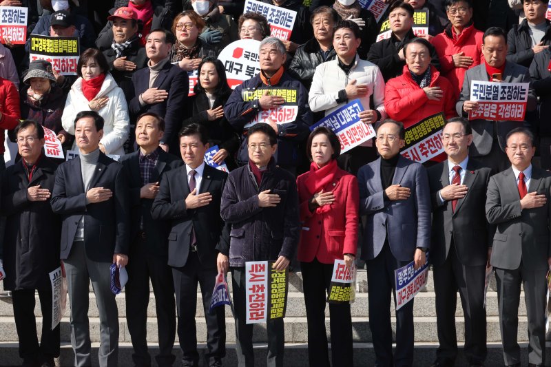 [서울=뉴시스] 조성봉 기자 = 이철우 경북도지사와 국민의힘 의원들을 비롯한 참석자들이 4일 오후 서울 여의도 국회 본청 계단에서 열린 '대구경북행정통합특별법 통과 촉구 대구경북 결의대회'에서 국민의례를 하고 있다. 2026.03.04. suncho21@newsis.com