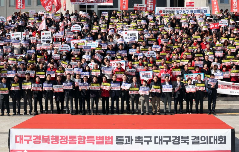 [서울=뉴시스] 조성봉 기자 = 이철우 경북도지사와 국민의힘 의원들을 비롯한 참석자들이 4일 오후 서울 여의도 국회 본청 계단에서 열린 '대구경북행정통합특별법 통과 촉구 대구경북 결의대회'에서 손피켓을 들고 구호를 외치고 있다. 2026.03.04. suncho21@newsis.com