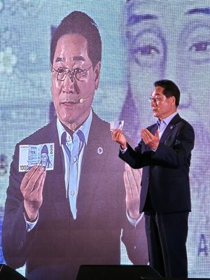 유정복 시장이 4일 인천 선학체육관에서 열린 자서전 출판기념회에서 천원짜리 지폐를 꺼내 민선8기 주요 정책인 천원정책을 설명하고 있다. 독자 제공.