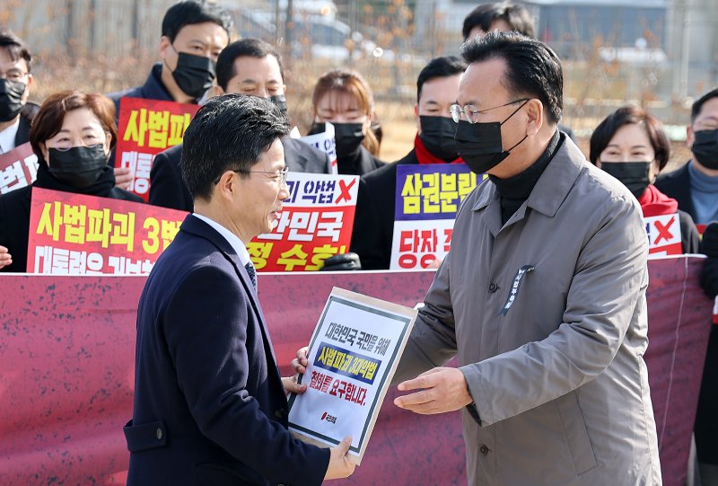 국민의힘 유상범 원내운영수석부대표가 5일 청와대 사랑채 앞에서 열린 의원총회에서 정을호 청와대 정무비서관에게 '3대 사법 파괴 악법' 철회 요구서를 전달하고 있다. 연합뉴스
