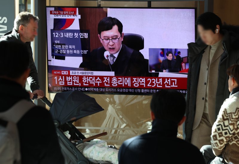 [서울=뉴시스] 조성우 기자 = 한덕수 전 국무총리의 내란 우두머리 방조, 내란 중요임무 종사 혐의 사건 1심 선고 재판이 열린 지난 1월21일 오후 서울역 대합실에서 시민들이 한 전 총리의 1심 징역 23년 선고 관련 뉴스를 시청하고 있다. 2026.03.11. xconfind@newsis.com