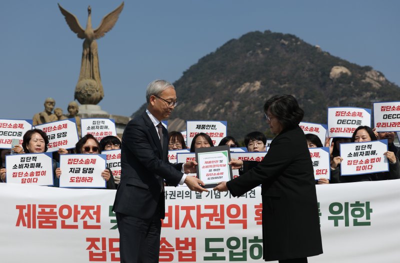 세계소비자권리의날(3월15일)을 앞두고 12일 서울 종로구 청와대 앞에서 열린 소비자 안전 및 소비자 권익 확보를 위한 집단 소송법 도입 촉구 기자회견에서 문미란 한국소비자단체협의회장이 주진우 청와대 공공갈등조정비서관에게 자료를 전달하고 있다. 연합뉴스