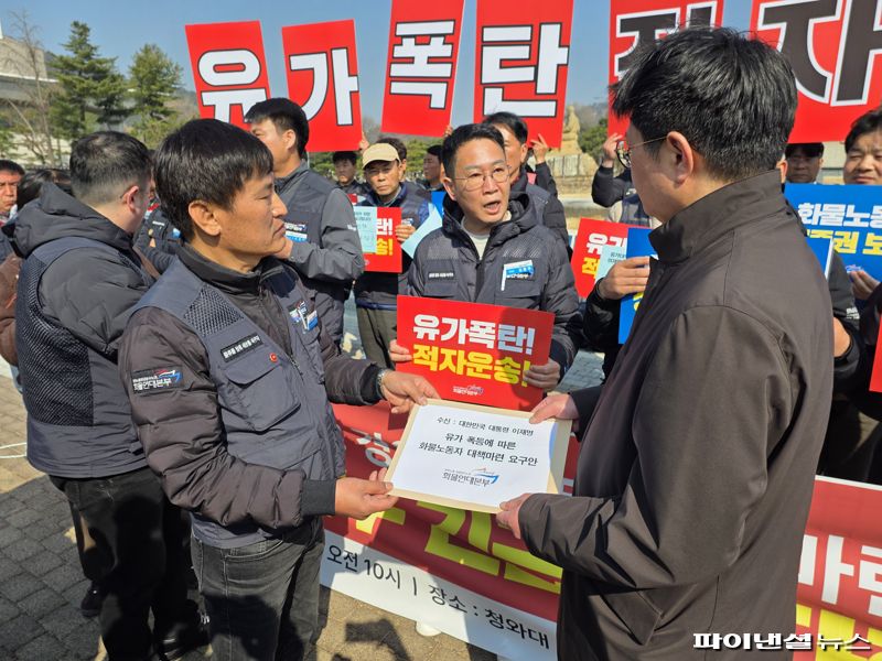 12일 오전 서울 종로구 청와대 사랑채 앞에서 민주노총 공공운수노조 화물연대본부 주최로 열린 '유가폭등 적자운송! 경유값 폭등 대책마련 촉구 기자회견' 종료 후 화물연대가 정경인 청와대 국토교통비서관실 행정관(오른쪽)에게 '생계대책 요구안'을 전달하고 있다. 사진=박성현 기자