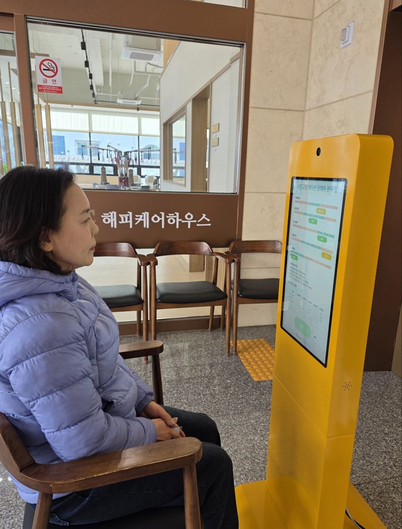 부산 남구 대연동 해피케어하우스 입구에 설치된 '키오스크 트리거 기반 다중 웨어러블 연동 케어 모니터링 시스템'을 이용하고 있는 모습. (주)해피케이365 제공