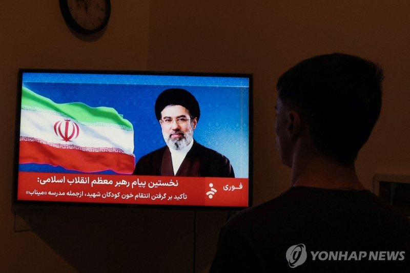 12일(현지시간) 모즈타바 하메네이 이란 새 최고지도자의 연설을 지켜보는 남성 (출처=연합뉴스)