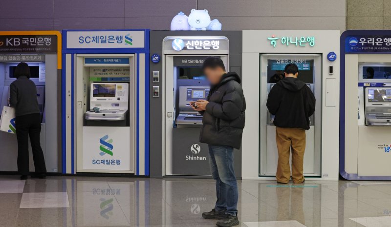 [서울=뉴시스] 조성우 기자 = 12일 서울 시내의 한 건물에서 시민들이 시중은행 ATM기기를 이용하고 있다.KB·신한·하나·우리·NH농협 등 5대 금융그룹은 지난해 당기순이익 20조 4700억 원을 기록하며 사상 처음으로 '20조 원 시대'를 열었다. 이는 전년(18조 8742억 원) 대비 1조 5958억 원(8.45%) 증가한 규모다. 2026.02.12. xconfind@newsis.com