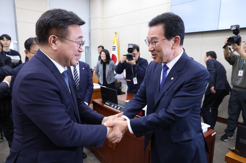 윤호중 행정안전부 장관이 18일 서울 여의도 국회에서 열린 행정안전위원회 전체회의에서 신정훈 위원장과 인사하고 있다. 2026.3.18 ⓒ 뉴스1 신웅수 기자