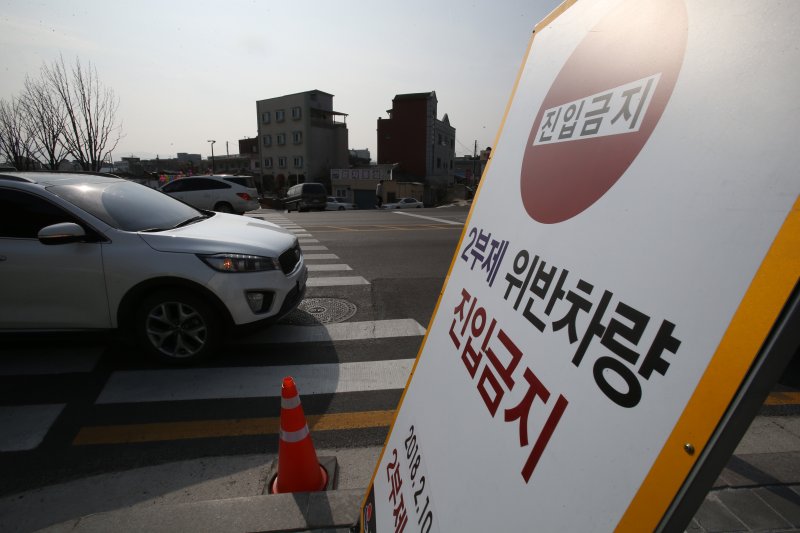[강릉=뉴시스]김경목 기자 = 교통통제요원이 지난 2018년 2월25일 강원 강릉시 교2동 지역에서 2부제 위반차량을 단속하고 있는 모습. 2018.02.26. photo31@newsis.com