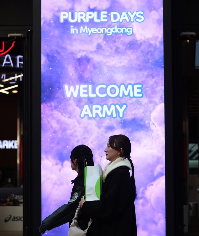 방탄소년단(BTS) 완전체 컴백 공연을 이틀 앞둔 19일 서울 중구 명동거리의 한 상점에 BTS 팬클럽 아미들을 환영하는 '퍼플데이' 할인 문구가 표시되고 있다. 뉴스1