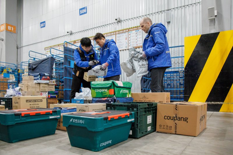 로저스 대표와 염태영 더불어민주당 의원이 배송체험에 앞서 택배물품 상차 등 준비 작업을 하고 있는 모습