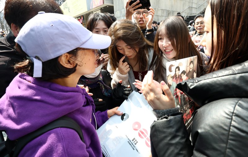 방탄소년단(BTS) 완전체 컴백 공연을 앞둔 20일 서울 광화문광장에서 BTS 팬이 포토카드를 비롯한 굿즈를 나눔하고 있다. 2026.3.20 ⓒ 뉴스1 최지환 기자