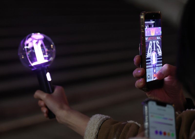 [서울=뉴시스] 김진아 기자 = 방탄소년단(BTS)의 서울 광화문광장 컴백 공연을 닷새 앞둔 16일 서울 종로구 광화문광장에서 팬들이 BTS 응원봉을 들고 기념촬영을 하고 있다. 2026.03.16. bluesoda@newsis.com