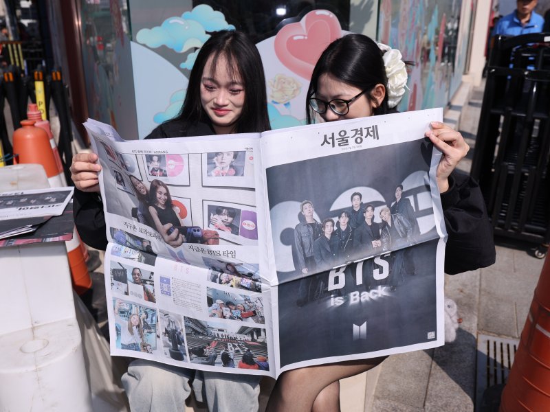 방탄소년단(BTS) 컴백 공연일인 21일 오전 서울 광화문광장에서 일본인 관광객들이 주요 일간지들이 발행한 BTS 특별판을 보고 있다. 2026.3.21 ⓒ 뉴스1 박지혜 기자