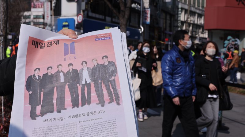 방탄소년단(BTS) 컴백 공연일인 21일 오전 서울 광화문광장에서 주요 일간지들이 발행한 BTS 관련 호외를 관계자가 배포하고 있다. 2026.3.212026.3.21 ⓒ 뉴스1 박지혜 기자