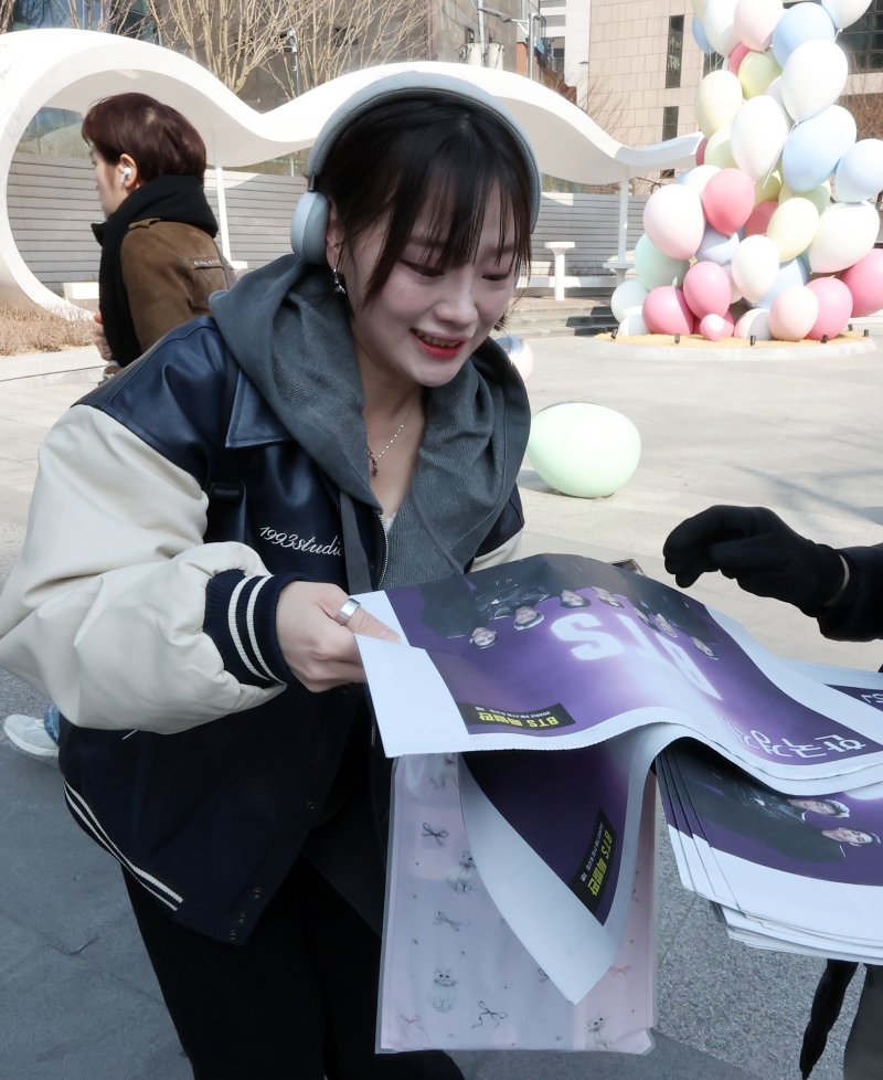 방탄소년단(BTS) 컴백 공연일인 21일 오전 서울 을지로입구역에서 한 외국인 관광객이 주요 일간지가 발행한 BTS 특별판을 받고 있다. 2026.3.21 ⓒ 뉴스1 김진환 기자