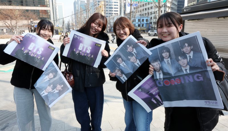 방탄소년단(BTS) 컴백 공연일인 21일 오전 서울 을지로입구역에서 일본인 관광객들이 주요 일간지들이 발행한 BTS 특별판을 들어보이고 있다. 2026.3.21 ⓒ 뉴스1 김진환 기자