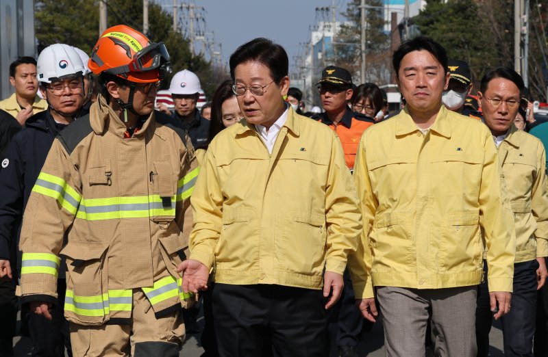 이재명 대통령이 21일 대전 대덕구 안전공업 건물의 대형 화재 현장을 찾아 상황보고를 받고 있다. 연합뉴스