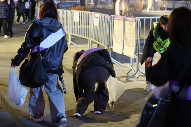 21일 서울 종로구 광화문 광장에서 열린 'BTS 컴백 라이브: 아리랑(ARIRANG)' 공연이 끝난 뒤 아미 자원봉사자가 쓰레기를 정리하고 있다. 사진=뉴시스화상