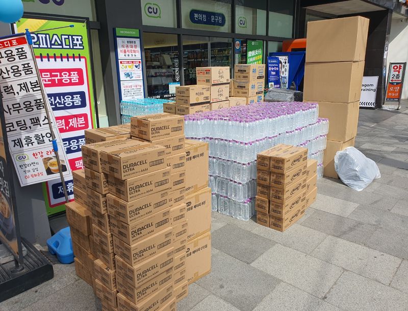 23일 오후 광화문 인근 한 편의점 앞에 BTS 공연 이후 반품을 앞둔 생수와 건전지 등이 박스 단위로 쌓여 있다. 공연 수요를 예상해 대량 발주했지만 인파 통제로 유입이 제한되면서 재고 부담이 발생한 모습이다. 사진=최승한 기자