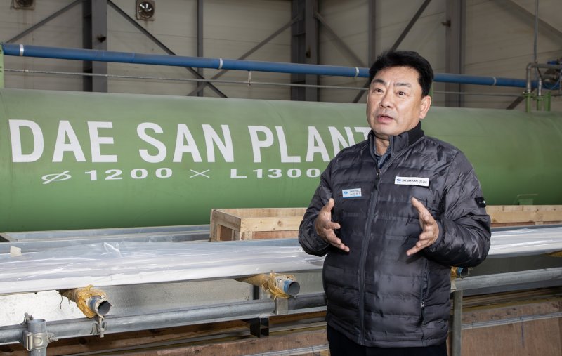 지난 17일 경남 김해시 한림면 안하농공단지 내 국내 유일의 대형 진공챔버(오토크레이브) 앞에서 이종욱 대산플랜트 대표가 설명하고 있다. 두산에너빌리티 제공