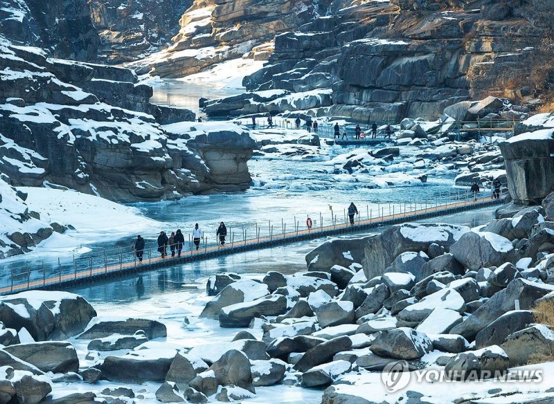 강원 철원군 한탄강 일원에서 개막한 '2026 철원한탄강얼음트레킹축제'에서 탐방객들이 물윗길을 걷고 있다. 연합뉴스