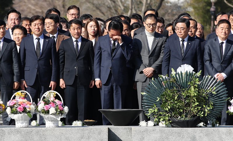 정청래 더불어민주당 대표가 23일 오전 경남 김해 진영읍 봉하마을을 찾아 고 노무현 전 대통령 묘역을 참배하며 손으로 얼굴을 닦고 있다. 2026.3.23 ⓒ 뉴스1 윤일지 기자