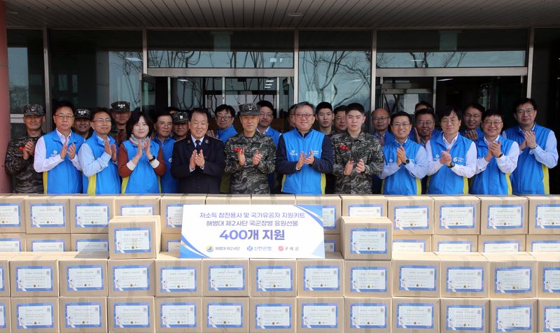 정상혁 신한은행장(앞줄 오른쪽 여섯번째부터) 최영길 해병대 제2사단장, 홍봉식 구세군 커뮤니케이션스국장 및 관계자들이 24일 경기도 김포시 소재 해병대 제2사단에서 진행한 ‘저소득 참전용사 및 국가유공자 지원 봉사활동’에서 기념촬영하는 모습. 신한은행 제공