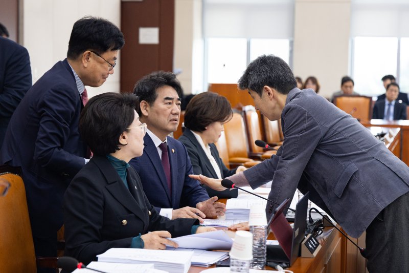 국회 행정안전위원회 여야 간사인 더불어민주당 윤건영(오른쪽), 국민의힘 서범수 의원이 24일 서울 여의도 국회에서 법안심사소위원회를 앞두고 이성권 국민의힘 의원과 대화를 나누고 있다. 2026.3.24 ⓒ 뉴스1 유승관 기자