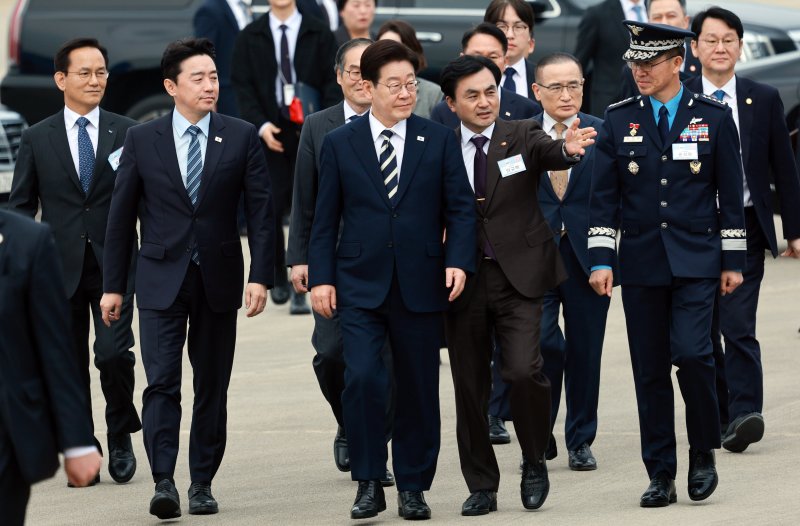 이재명 대통령이 25일 경남 사천 한국항공우주산업(KAI)에서 안규백 국방부 장관의 설명을 들으며 KF-21 양산 1호기 출고식에 입장하고 있다. 청와대통신사진기자단