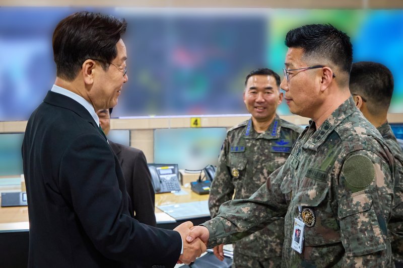 이재명 대통령이 27일 서울 용산 국방부에서 전군주요지휘관회의를 마친 뒤 지휘통제실을 찾아 조성현 대령을 격려하며 악수하고 있다. 청와대 제공