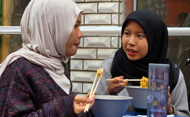 경북 구미에서 열리고 있는 '2025 구미라면축제' 행사장을 찾은 외국인 방문객이 주문한 라면을 먹으며 즐거운 시간을 보내고 있다. 2025.11.8 ⓒ 뉴스1 정우용 기자