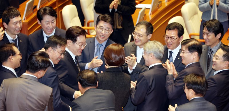 이재명 대통령이 2일 국회에서 2026 추가경정예산안 시정연설을 위해 본회의장에 입장하며 더불어민주당 의원들과 인사하고 있다. 연합뉴스