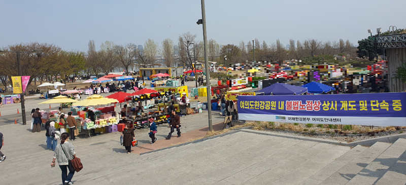 지난 3일 ‘불법 노점상 상시 계도 및 단속 중’ 현수막이 설치된 여의도 한강공원 일대에서 노점들이 줄지어 영업하고 있다. 단속 안내에도 불구하고 공원 주요 동선 곳곳에서 노점이 성업 중이다. 사진=최승한 기자