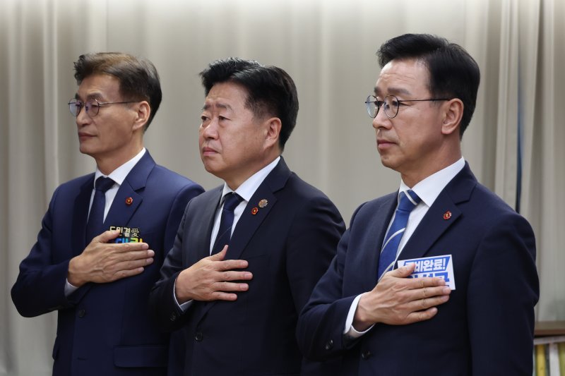 더불어민주당 문대림(왼쪽부터), 오영훈, 위성곤 제주도지사 경선 후보가 6일 서울 여의도 당사에서 열린 제주도지사 본경선 합동연설회에서 국민의례를 하고 있다. 경선 막판 제주 민주당은 문자메시지 논란과 추자 해상풍력 문제를 둘러싼 충돌이 이어지고 있다. /사진=뉴시스