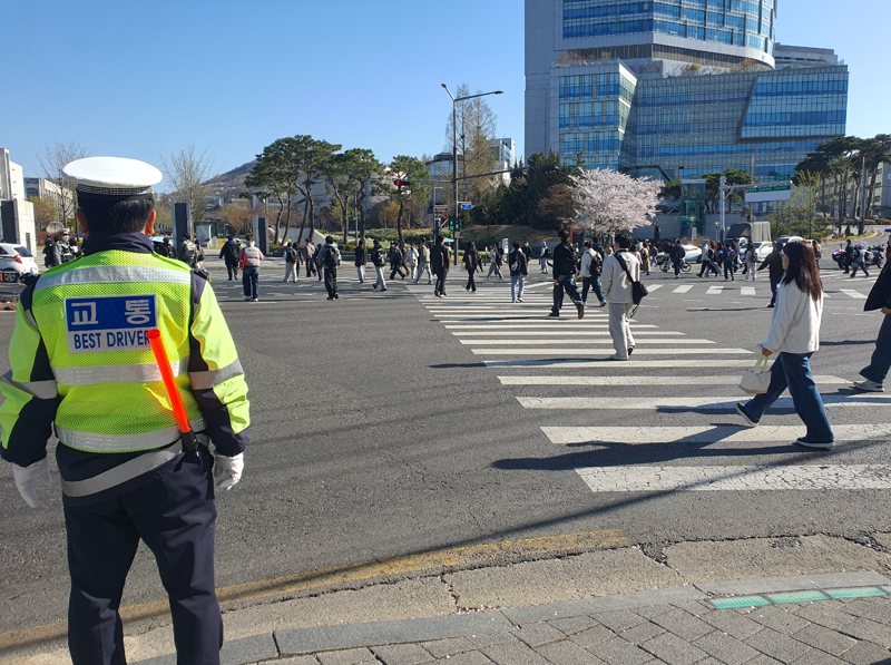 7일 오전 서울 서대문구 연세대 정문 앞 교차로에서 교통경찰이 출근길 시민과 학생들이 한꺼번에 횡단보도를 건너는 모습을 지켜보고 있다. 사진=최승한 기자