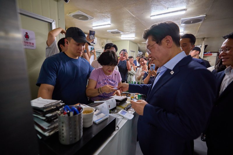 [서울=뉴시스] 이재명 대통령이 지난해 7월11일 서울 종로구 한 식당에서 시민들과 '삼겹살 외식'을 마치고 계산을 하고 있다. (사진=대통령실 제공) 2025.07.12. photo@newsis.com *재판매 및 DB 금지