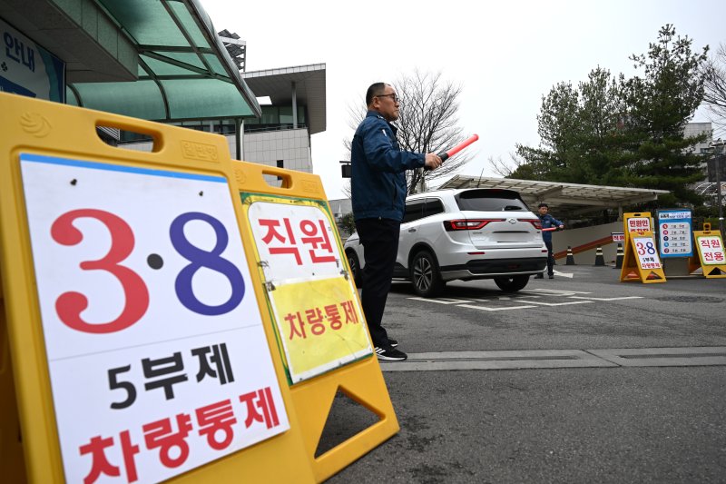 [광주=뉴시스] 이현행 기자 = 중동전쟁 여파에 따른 에너지 절약 정책으로 차량 5부제가 시행된 첫날인 25일 오전 광주 서구청에서 한 차량이 청원경찰의 안내를 받고 진입하고 있다. 2026.03.25. lhh@newsis.com