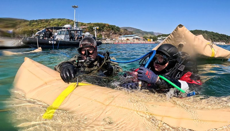 8일 경남 진해만 일대에서 진행된 연합 구조전 훈련에서 한국ㆍ호주 해군 잠수사들이 모의 침몰 선박 인양을 위해 리프팅백에 공기를 주입하고 있다. 해군 제공