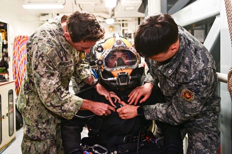 8일 경남 진해만 일대에서 진행된 연합 구조전 훈련에서 수상함구조함 통영함에 편승한 한미 해군 잠수사들이 호주 해군 잠수사의 잠수장비 착용을 돕고 있다. 2026.4.9 [해군 제공