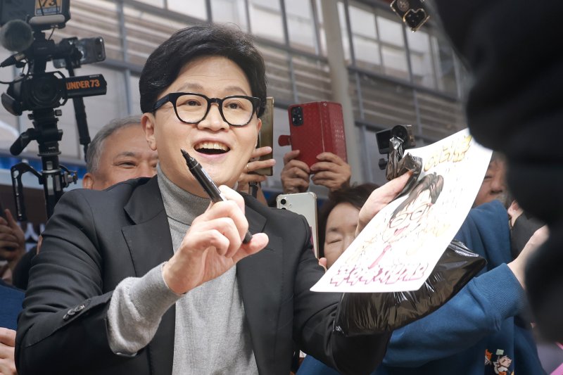 [서울=뉴시스] 정병혁 기자 = 한동훈 전 국민의힘 대표가 22일 서울 동대문구 경동시장을 찾아 시장상인에게 사인을 해주고 있다. (공동취재) 2026.03.22. photo@newsis.com