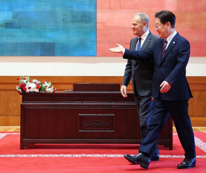 이재명 대통령과 도날드 투스크 폴란드 총리가 13일 청와대에서 정상회담에 앞서 기념촬영을 하기 위해 이동하고 있다. 청와대통신사진기자단