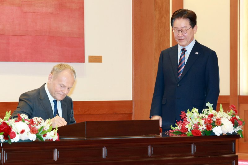 이재명 대통령이 13일 청와대에서 정상회담에 앞서 도날드 투스크 폴란드 총리의 방명록 작성을 지켜보고 있다. 청와대통신사진기자단